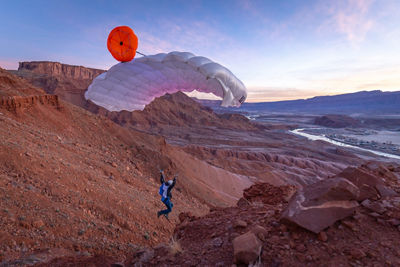 Person Parachuting Through Mountains