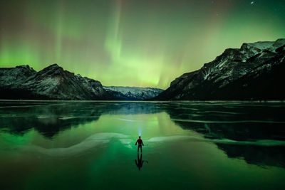 Mountains and Hiker with Aurora Borealis in the Sky