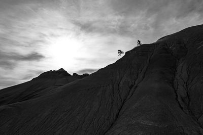 Black and White Picture of Biker Riding Down a Mountain