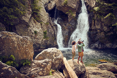 Couple taking photo in front of a waterfall