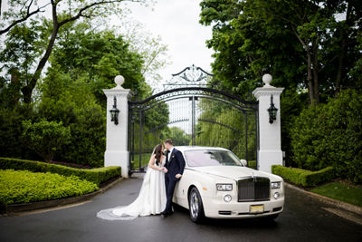 Bride and Groom Kissing Near a Limo