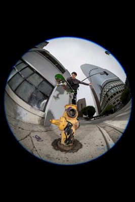 Fisheye View of a Skateboarder Jumping Over a Fire Hydrant