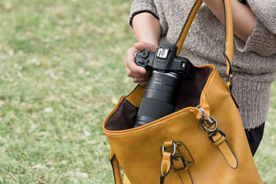 Person Putting Away Canon Camera into a Bag