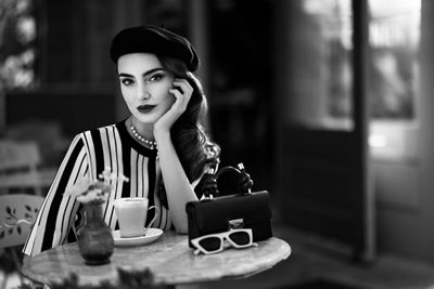 Gray Photo of a Model Sitting at a Table