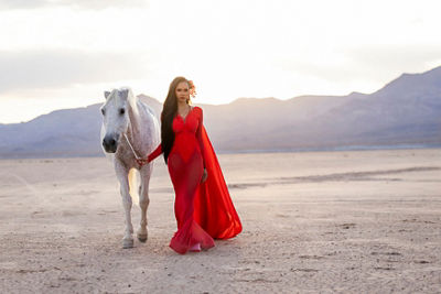 Person Walking with a Horse in a Dessert