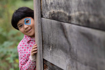 Kid Peeking From a Wooden Wall