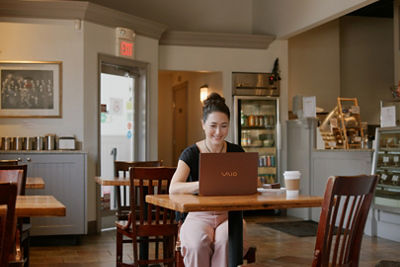 Person Using a VAIO Laptop in a Coffee Shop