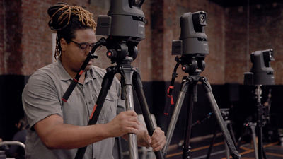 man setting up a PTZ camera on a tripod