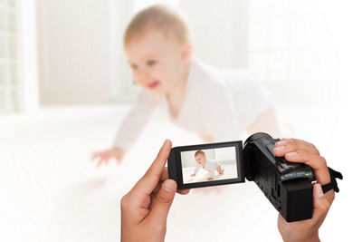 Individual using camcorder to videotape a baby