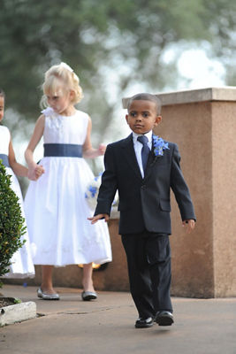 flower girls and ring bearer walking around a bush