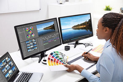 A woman reviewing a print job on a monitor