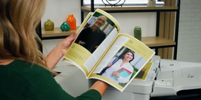 Canon printer in an office backlit by bright windows.