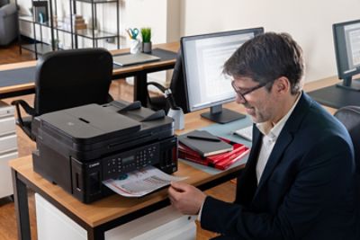 Canon MAXIFY printer sits on a desk in an office