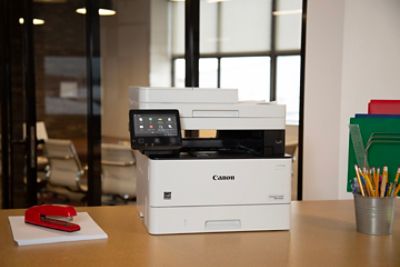 Laser Printer sits on a desktop with small office supplies