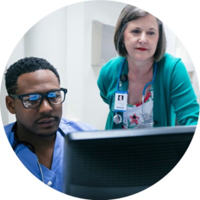 Doctor and nurse discussing something on computer screen