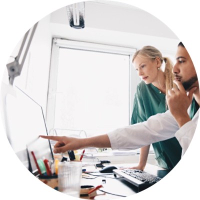 Man sitting next to woman and pointing to a computer screen