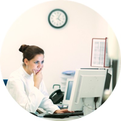 Woman with hand on her chin looking at computer monitor