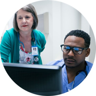 Doctor and nurse discussing something on computer screen