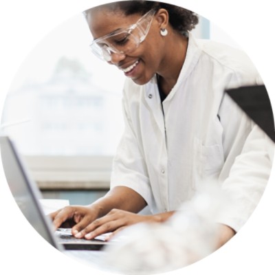 Woman in lab coat using laptop computer