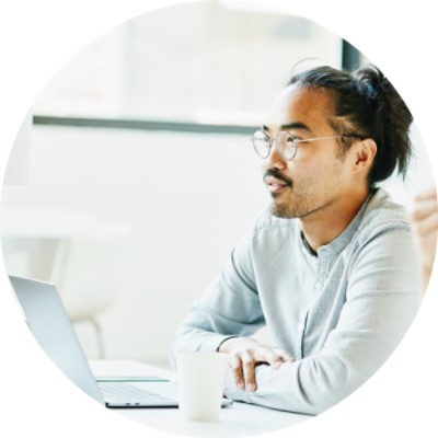 Man sitting at table looking at a laptop computer