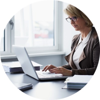 Woman typing on keyboard and looking at laptop