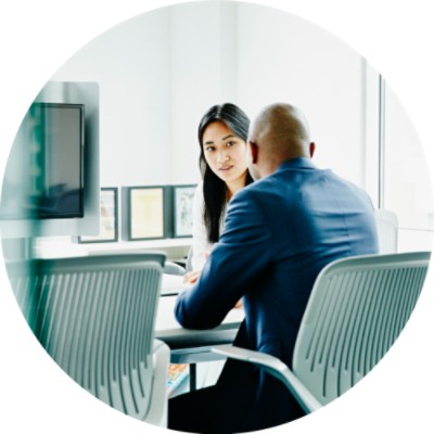 Man and woman sitting at desk and talking