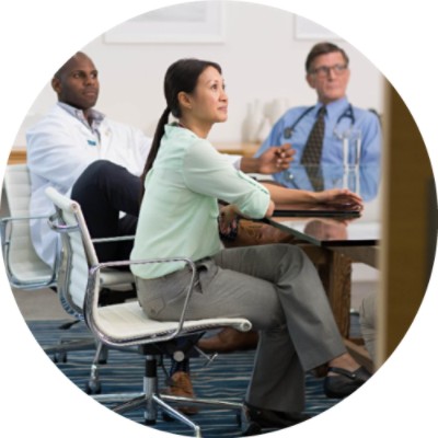 Three people sitting at conference table