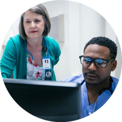 Doctor and nurse discussing something on computer screen