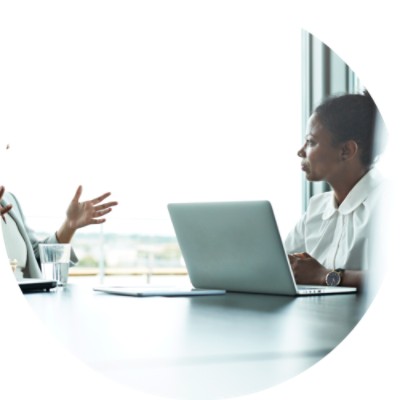 Two women talking at conference table