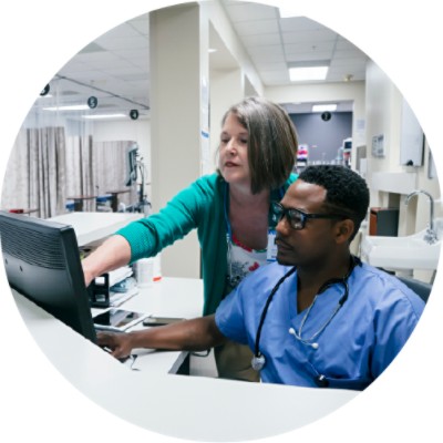 Doctor and nurse discussing something on computer screen