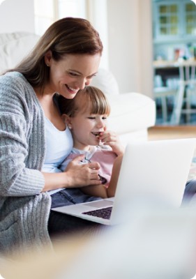 Woman and child smiling at computer screen