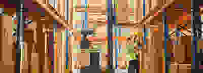 Two employees in a warehouse looking at boxes