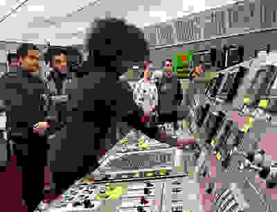 Kids around a control room touching equipment