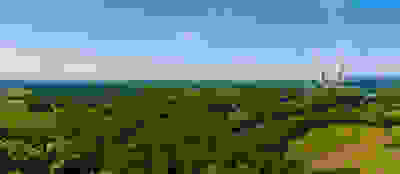 Plant with two cooling towers in the distance behind lots of greenery and land
