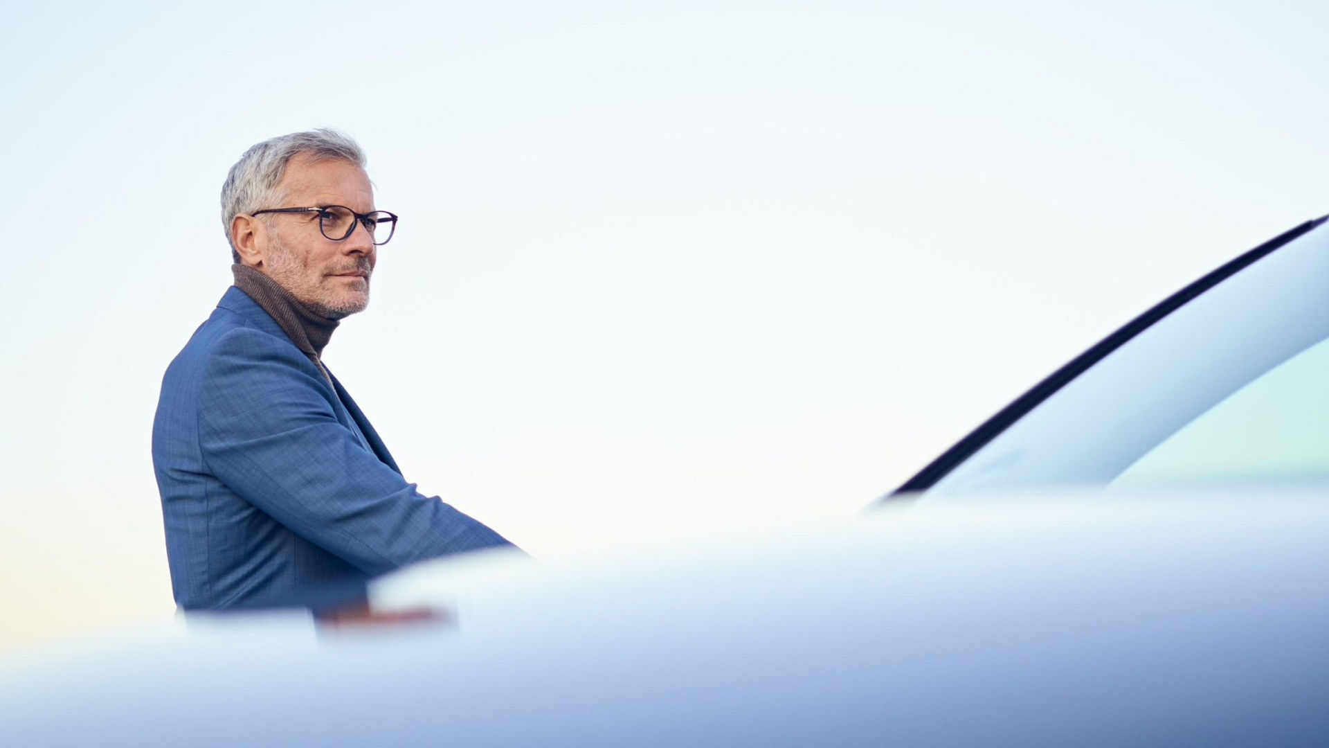 Man stood by car wearing blue