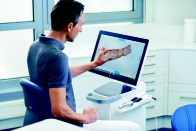 Male dental professional using CEREC Software on a screen