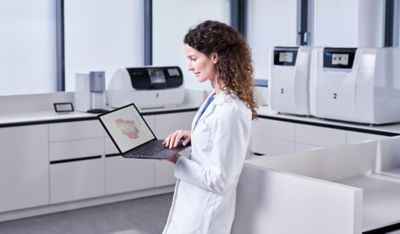 Dentist using a computer with DS Core cloud platform for digital dental workflows.