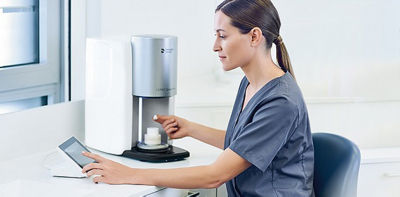 Dental professional finalizing a crown restoration in the CEREC SpeedFire furnace during the sintering and finishing step