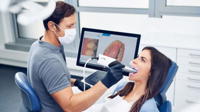 Dentist using Primescan intraoral scanner to capture a 3D digital impression of a patient’s teeth