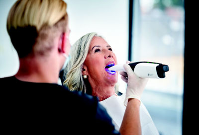 Dentist using Primescan intraoral scanner to capture a 3D digital impression of a patient’s teeth