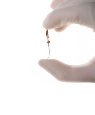 Gloved hand holding the R-Pilot™ glide path file, designed for controlled, reciprocating root canal preparation.