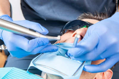 Dental professional doing an endodontic procedure on a patient using WaveOne Gold files in a clinical setting.
