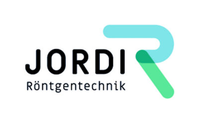 Front of Dentsply Sirona office building with trees and hedges in foreground.