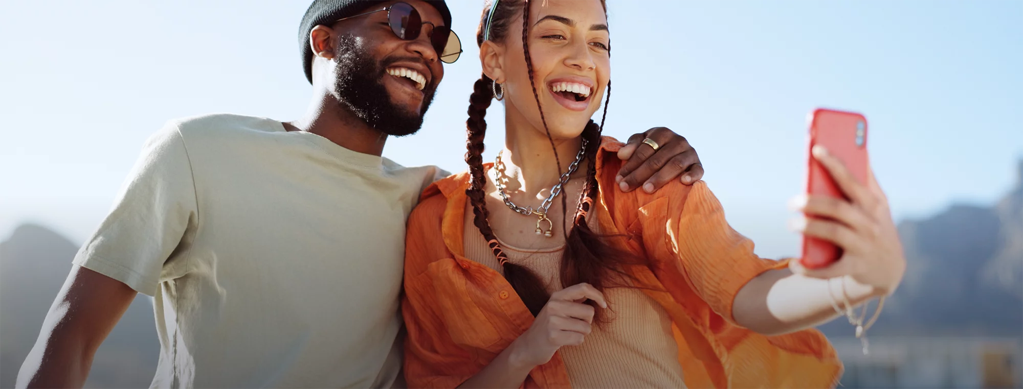 man and woman holding phone