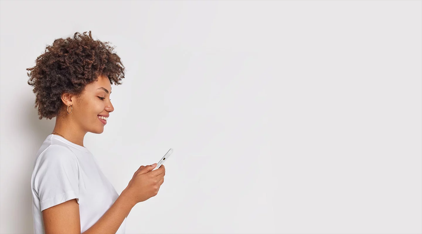 A young smiling woman using her smartphone