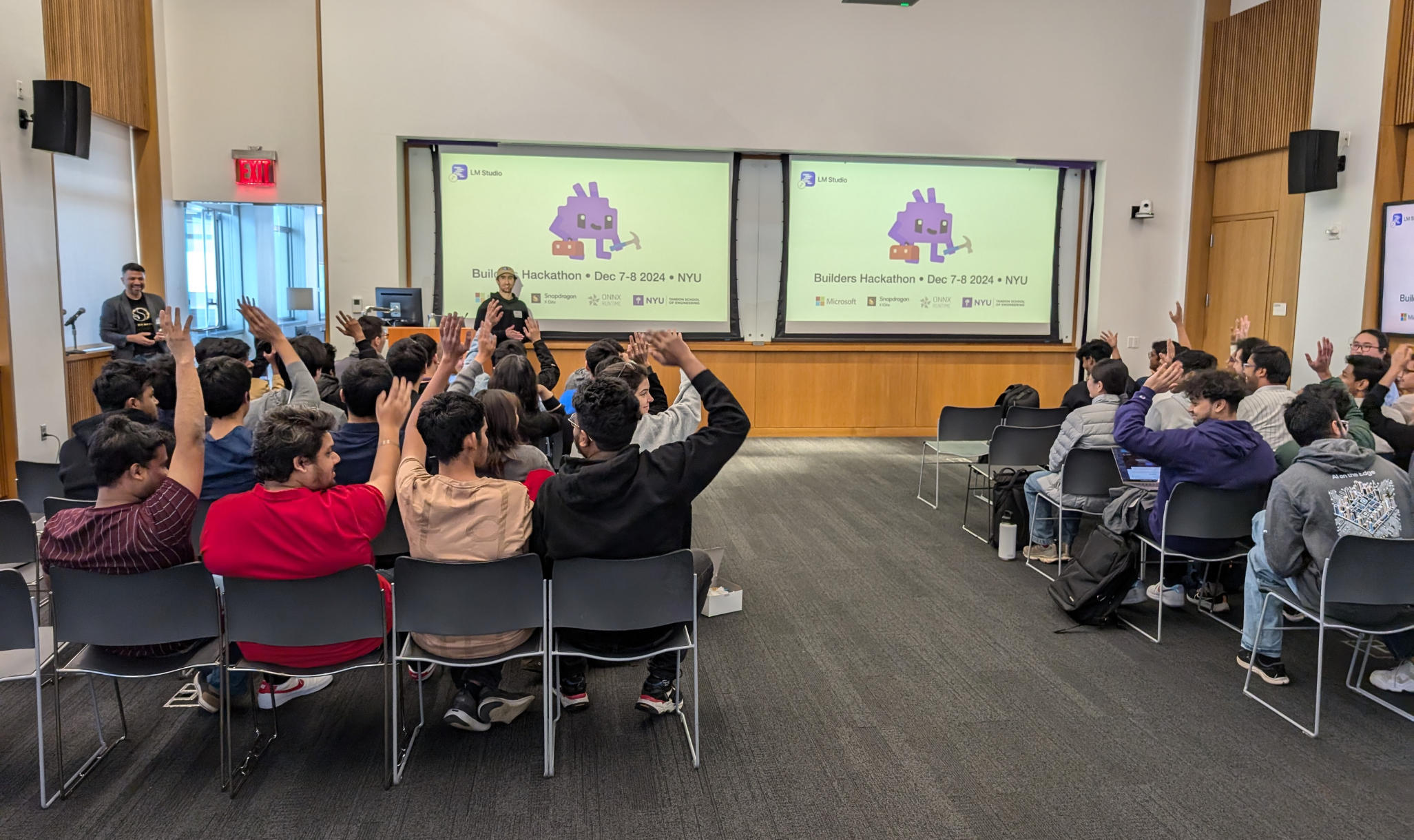 A group of people in a room with a projection screen