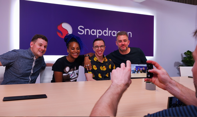 Kevin Breeze, Lucy Hedges, Austin Evans, and Paul Smith pose together for a picture at Computex. They are backdropped by the Snapdragon logo.