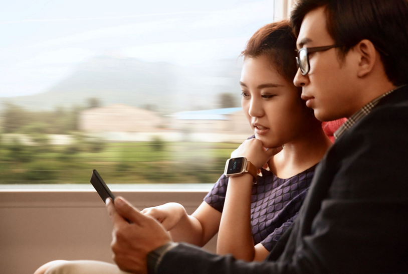 A couple on a train using a smartphone with generative AI capabilities.