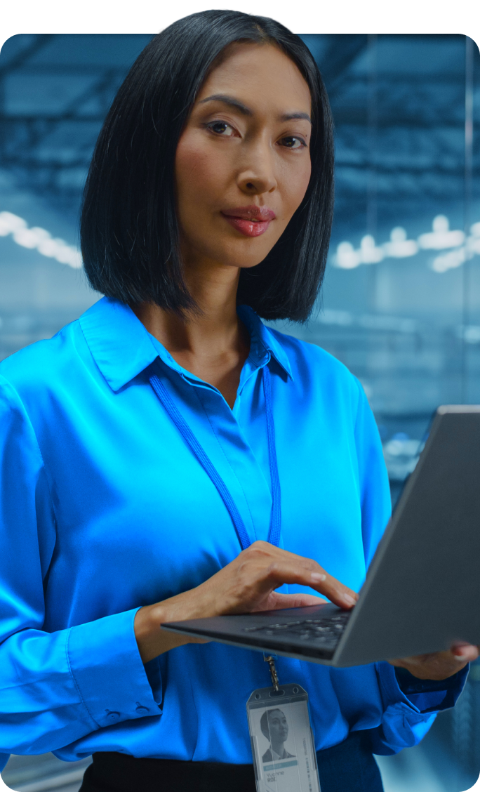 Confident IT professional using a laptop in a data center with digital overlays featuring reduced cost of ownership and efficient deployment capabilities.