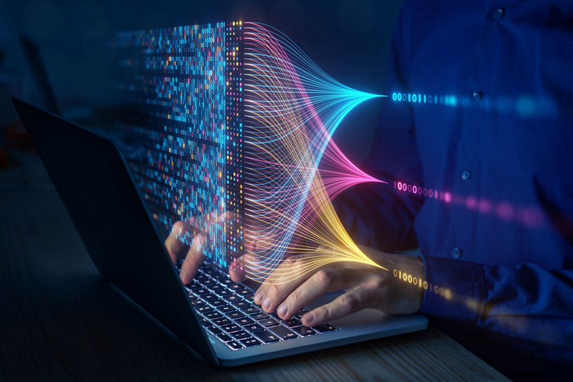 Binary code being read by a person sitting at a laptop.
